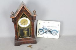 A steeple mantel clock with key and pendulum and a modern wall clock depicting a Harley - Davidson