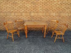 A pine kitchen table and four chairs, table approximately 75 cm x 122 cm x 79 cm.