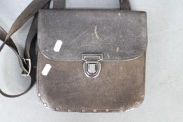 A vintage leather bus driver's pouch with strap handle.