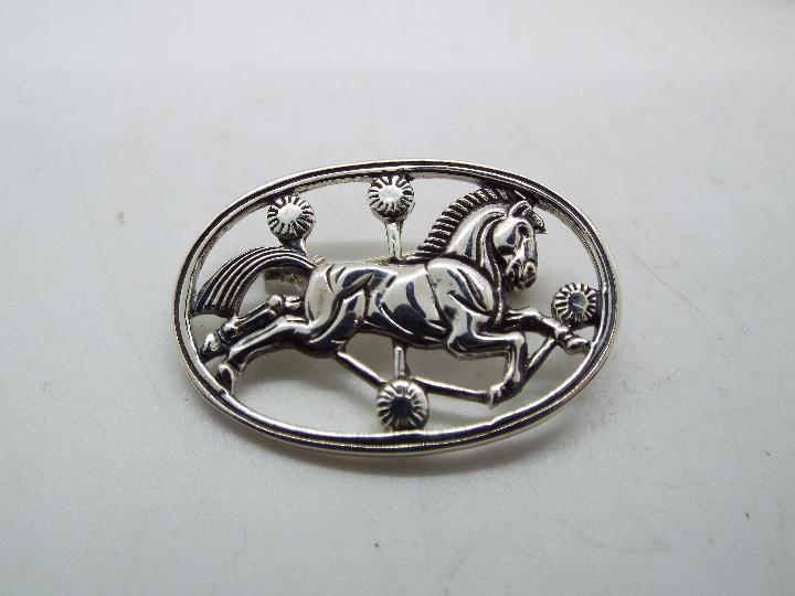 Silver - a silver brooch with a horse design,