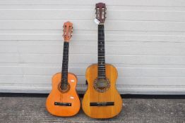Two child's acoustic guitars, one by Encore and one other.