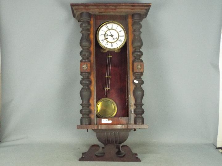 A mahogany cased wall clock with pendulu