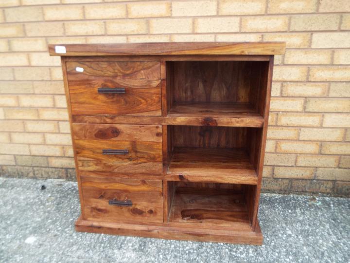 A chest of three drawers with shelving s