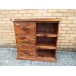 A chest of three drawers with shelving s