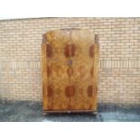 A burr walnut veneered twin door wardrob