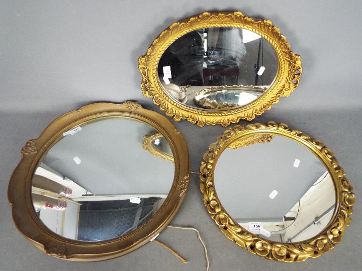 Three decorative wall mirrors, largest a