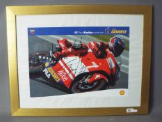 A signed image depicting Troy Bayliss riding for Ducati, framed under glass,