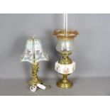 A brass oil lamp with ceramic reservoir, glass shade and chimney,