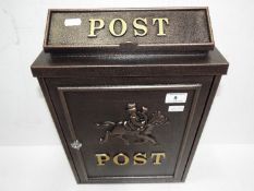 A modern black post box, horse and rider design,