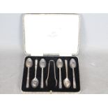 A George V cased set of silver coffee spoons comprising six spoons and sugar tongs,