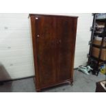 A good quality twin door wardrobe with fitted interior, raised on four supports,