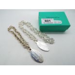 Two white metal oval tags and chains, the tags stamped Please Return To Tiffany & Co New York,