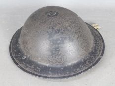 A Brodie type steel helmet with strap and liner, undated.