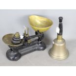 A vintage set of kitchen scales and weights and a brass hand bell with turned wooden handle.