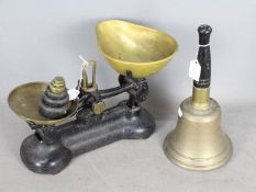 A vintage set of kitchen scales and weights and a brass hand bell with turned wooden handle.