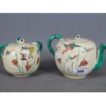 A Japanese teapot and sugar bowl with cover, hand painted decoration of birds in flight, signed.