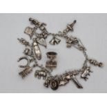 A white metal (presumed silver but unmarked) charm bracelet and charms, approximately 52.