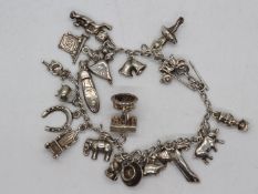 A white metal (presumed silver but unmarked) charm bracelet and charms, approximately 52.