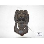 A cast iron door knocker in the form of a lion,