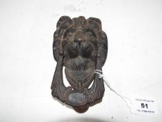 A cast iron door knocker in the form of a lion,