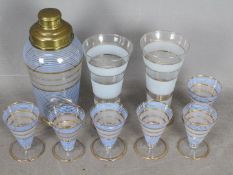 A vintage drinks set comprising a cocktail shaker, two highball glasses and six digestif.