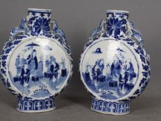 A pair of late 19th or early 20th century Chinese blue and white moon flasks raised on oval foot,