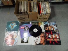 A collection of 12" vinyl records to include Peter Frampton, Johnny Cash, The Carpenters, The Doors,