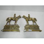 A pair of brass door stops in the form of horse riders,