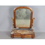 A Victorian toilet mirror with twin drawers to the base and raised on bun feet,