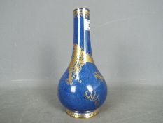 A Wedgwood bottle vase decorated with dragon against a blue ground, Portland vase mark to the base,