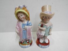 Two ceramic figurines depicting mother and father,