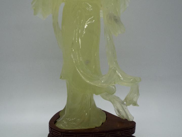 A Chinese, celadon green, bowenite carving of a lady in flowing robes holding a fan, - Image 3 of 3