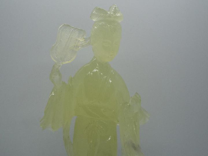 A Chinese, celadon green, bowenite carving of a lady in flowing robes holding a fan, - Image 2 of 3