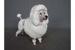 A Royal Doulton figurine depicting a lion cut poodle, approximately 13 cm (h).