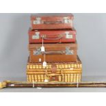 Three vintage cases, three walking sticks and a picnic set.