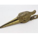 A late Victorian gilt metal paper clip in the form of a birds head, with glass eyes,