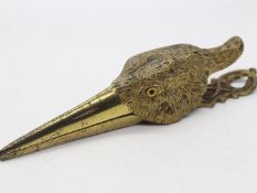 A late Victorian gilt metal paper clip in the form of a birds head, with glass eyes,