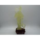 A Chinese, celadon green, bowenite carving of a lady in flowing robes holding a fan,