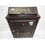 A modern black post box, horse and rider