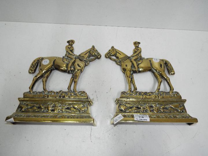 A pair of brass door stops in the form o