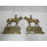 A pair of brass door stops in the form o