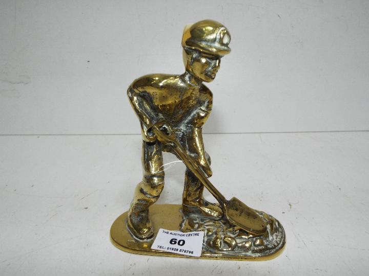 A brass figure in the form of a coal min