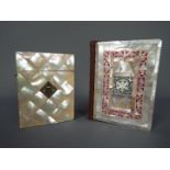 A mother of pearl calling card case with hinged cover and inset white metal plaque and a mother of