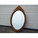 An ornately framed, bevel edge wall mirror, approximately 95 cm x 56 cm.