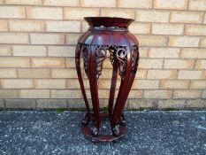 A Chinese hardwood jardiniere stand with carved detailing, approximately 62 cm x 30 cm.