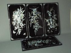 A set of four decorative lacquered panels, each approximately 59 cm x 29 cm.