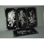 A set of four decorative lacquered panels, each approximately 59 cm x 29 cm.