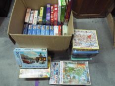 A large quantity of jigsaw puzzles, approximately 40 items in total.