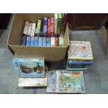 A large quantity of jigsaw puzzles, approximately 40 items in total.