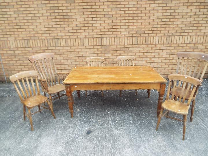 A pine dining table measuring approximately 73 cm x 172 cm x 99 cm with four chairs and two carvers.